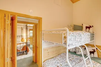 a bedroom with two bunk beds and a mirror at 3 Mi to Snow Summit Charming Home with Fenced Yard in Big Bear Lake