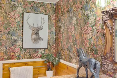 a room with a painting of a deer on a floral wall at 3 Mi to Snow Summit Charming Home with Fenced Yard in Big Bear Lake