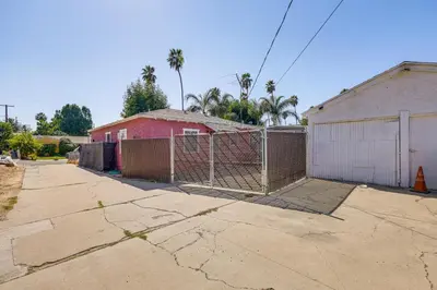 an empty parking lot with a fence and a building at High Walkability! Extended Stay in Riverside in Riverside