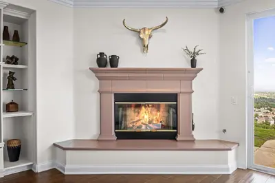 a fireplace in a living room with a antelope on the wall at Modern Hilltop Retreat in Lakeside Park
