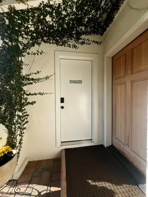 a white door with a sign on it next to a building at Charming Cozy Studio 5 Minutes from Sofi Stadium in Los Angeles