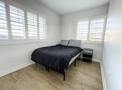 a bedroom with a bed in a room with windows at Soulistic Vibes Normandie in Los Angeles