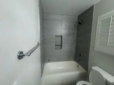 a white bathroom with a tub and a toilet at Soulistic Vibes Normandie in Los Angeles