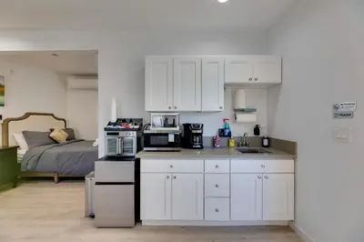 a kitchen with white cabinets and a bed in a room at 4 Mi to Old Pasadena Walkable Studio in Alhambra