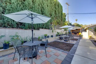 a patio with tables and chairs and an umbrella at 2 Blocks to Main St Foodies Paradise in Alhambra in Alhambra