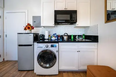 a kitchen with a washing machine and a microwave at Remodeled Chick Studio Near Downtown LA, AC, WiFI, WD, Snack in Los Angeles