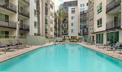 a large swimming pool with chairs and buildings at Stylish Studio in Mid-Wilshire with Pool, Free Parking, Gym in Prime Location in Los Angeles