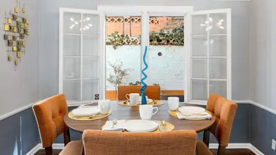 a dining room with a table and chairs and windows at Cozy Hollywood Hideaway w Private Patio Easy City Access Casa Camrose by AvantStay in Los Angeles