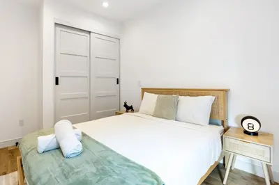 a bedroom with a large white bed and a table at Platinum Suite LA in Los Angeles