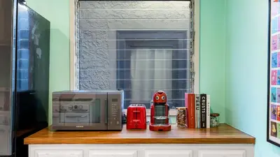 a microwave sitting on top of a wooden shelf at Spanish Revival Charm in Silver Lake w Patio BBQ Walkable Location Maltman Manor by AvantStay in Los Angeles