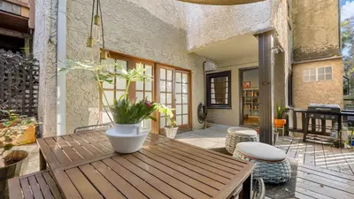 a patio with a wooden table and a potted plant at Spanish Revival Charm in Silver Lake w Patio BBQ Walkable Location Maltman Manor by AvantStay in Los Angeles