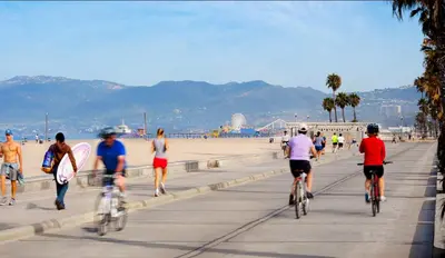 a group of people riding bikes on the beach at Santa Monica Ocenfront 2 Bedroom Villa with Parking in Los Angeles