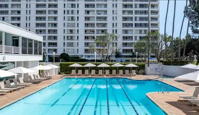 a swimming pool with chairs and a large building at Santa Monica Ocenfront 2 Bedroom Villa with Parking in Los Angeles