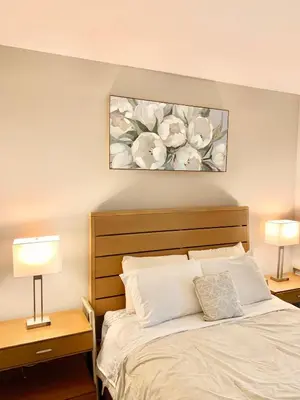 a bedroom with a bed with two lamps and a painting at Contemporary 2BR Prime Hollywood Location in Los Angeles