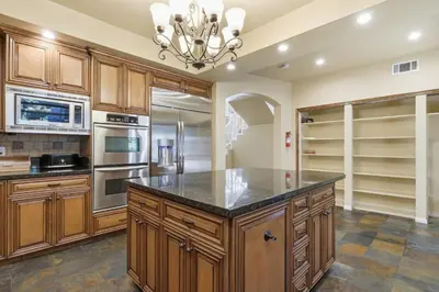 a large kitchen with wooden cabinets and a large island at Spacious Mountain Getaway Game Room & Gazebo villa in Pine Mountain Club