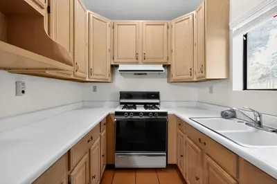 a kitchen with wooden cabinets and a stove top oven at Spacious Mountain Getaway Game Room & Gazebo villa in Pine Mountain Club