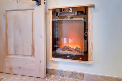 a fireplace in a wooden cabinet in a room at Walk to Village! Romantic Pine Mtn Nature Escape in Pine Mountain Club