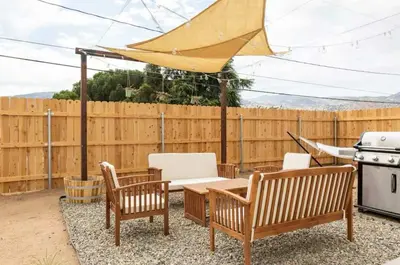 a patio with a table and chairs and a grill at Huth Street Haven in Lake Isabella