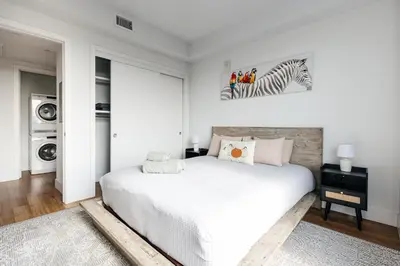 a white bedroom with a bed and a zebra picture on the wall at High End Hotel Style 2B apartment with two balconies in Los Angeles