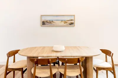 a wooden table with chairs and a picture on the wall at Metro Loft LA in Los Angeles