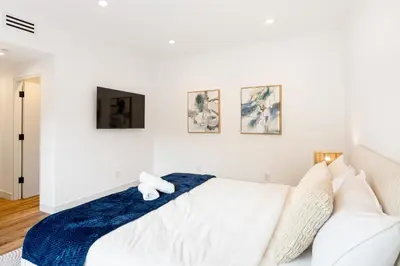 a bedroom with a white bed with a blue blanket at Metro Loft LA in Los Angeles