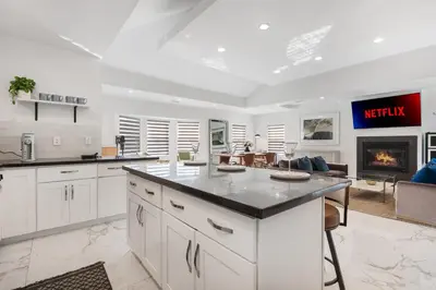 a kitchen with white cabinets and a living room at Serene Luxe Residence near Rose Bowl in Pasadena