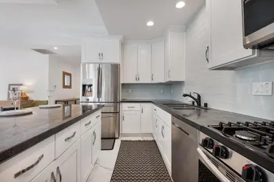 a kitchen with white cabinets and a sink and a stove at Serene Luxe Residence near Rose Bowl in Pasadena