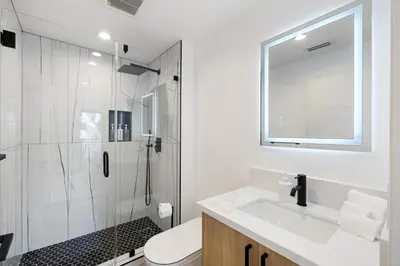 a white bathroom with a shower and a sink at Sky Haus LA in Los Angeles