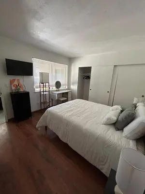 a bedroom with a bed and a desk and a window at Pet friendly 3BR Spacious Home EV in Riverside