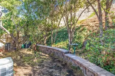 a brick retaining wall in a yard with trees at Pet friendly 3BR Spacious Home EV in Riverside