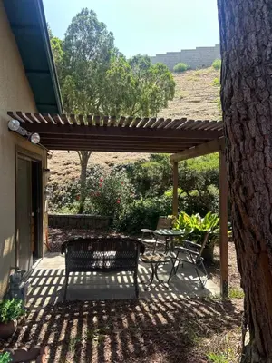 a patio with a table and chairs under a wooden pergola at Pet friendly 3BR Spacious Home EV in Riverside