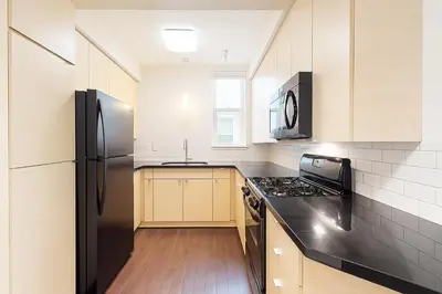 a kitchen with a black refrigerator and a sink at Modern 1BR Retreat in Marina del Rey - Pool, Hot Tub & Gym, Sauna in Los Angeles