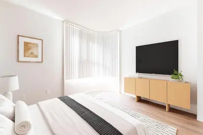 a white bedroom with a large bed and a flat screen tv at Modern 1BR Retreat in Marina del Rey - Pool, Hot Tub & Gym, Sauna in Los Angeles