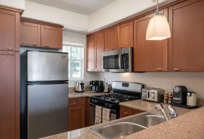 a kitchen with wooden cabinets and a stainless steel refrigerator at Relaxed Marina del Rey Stay - 1BR with Pool, Sauna & Gym Access in Los Angeles