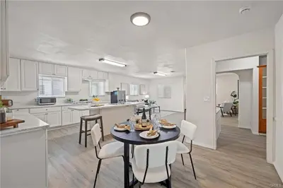 a kitchen and dining room with a table and chairs at 4 bedrooms in Long Beach