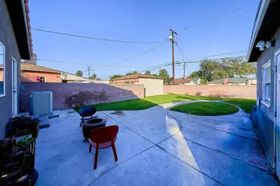 a patio with two red chairs and a yard at 4 bedrooms in Long Beach