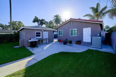 a small house with a backyard with a lawn at 4 bedrooms in Long Beach