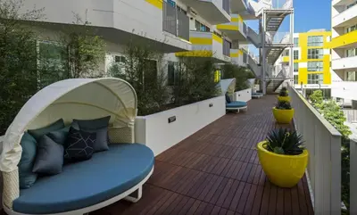 a balcony with a blue couch on a wooden deck at Santa Monica 3BD Serenity Suite with FREE PARKING in Los Angeles