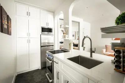 a white kitchen with a sink and a stove at Beverly Grove Hotel in Los Angeles