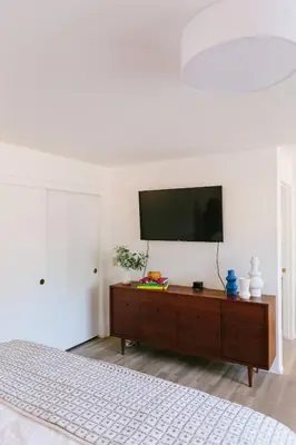a bedroom with a flat screen tv on a white wall at Heidi House Entire Duplex Relocation Stays in Redlands
