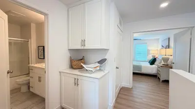 a white bathroom with a toilet and a bedroom at Modern Luxury House 3B&4B House 30 mins DTLA in Baldwin Park