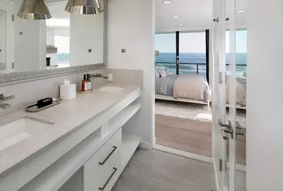 a bathroom with two sinks and a view of a bedroom at Rincon Refuge - Beachfront for 6 in Ventura