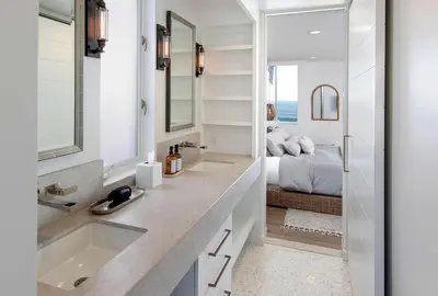 a bathroom with two sinks and a bedroom with a bed at Rincon Refuge - Beachfront for 6 in Ventura