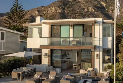 a house with a deck with chairs and tables at Rincon Refuge - Beachfront for 6 in Ventura