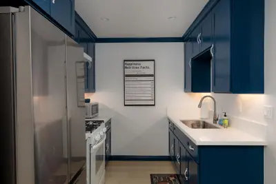 a kitchen with blue cabinets and a stainless steel refrigerator at Pet-Friendly 2BR-2BA Near SoFi-Small Dogs Welcome in Los Angeles