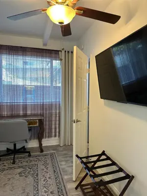 a living room with a ceiling fan and a flat screen tv at San Pedro Delight in San Pedro Peninsula Hospital Heliport