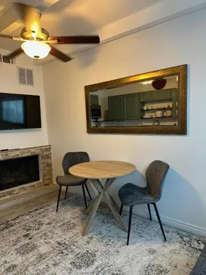 a dining room with a table and chairs and a mirror at San Pedro Delight in San Pedro Peninsula Hospital Heliport