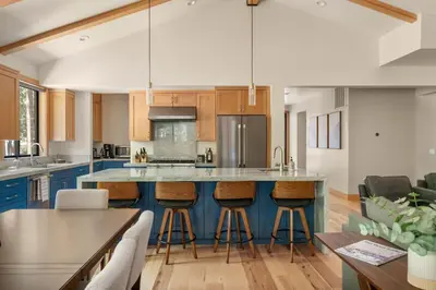 an open kitchen with blue cabinets and bar stools at 34 - The Maple Crest home in Big Bear Lake