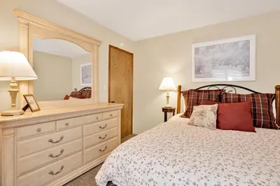 a bedroom with a bed with a dresser and a mirror at Summit Ski and Bike Trails #2574 in Big Bear Lake