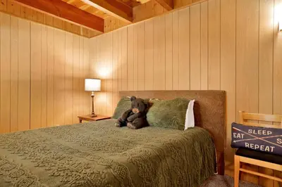 a teddy bear sitting on a bed in a bedroom at Slope Side Getaway #2526 in Big Bear Lake